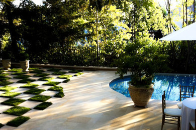 This is an example of a large back rectangular natural hot tub in Los Angeles with concrete slabs.