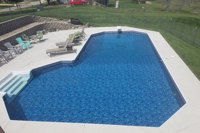 Example of a large classic backyard concrete and l-shaped pool design in St Louis