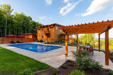 Example of a large trendy backyard rectangular natural pool design in New York