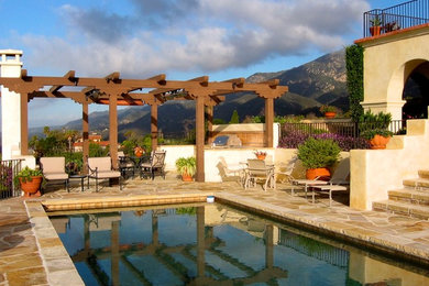 Large tuscan stone and rectangular pool photo in Santa Barbara
