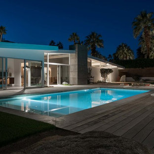 Imagen de piscinas y jacuzzis retro, de tamaño medio, rectangulares, en patio trasero, con losas de hormigón