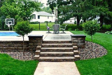 Example of a mid-sized classic backyard concrete paver and custom-shaped aboveground pool design in Minneapolis