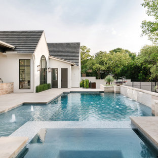 Immagine di una grande piscina mediterranea personalizzata dietro casa con fontane