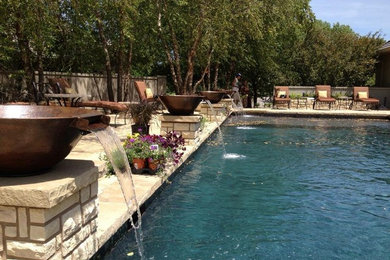 Diseño de piscinas y jacuzzis naturales rústicos grandes a medida en patio trasero con adoquines de piedra natural