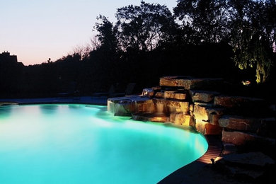 Cette image montre une piscine naturelle et arrière design de taille moyenne et sur mesure avec un point d'eau et des pavés en béton.