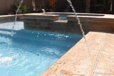 Imagen de piscina con fuente tradicional en patio trasero