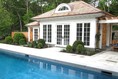 Example of a large transitional backyard stamped concrete and rectangular natural pool house design in New York