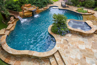 Réalisation d'une grande piscine naturelle et arrière chalet sur mesure avec des pavés en pierre naturelle et un bain bouillonnant.