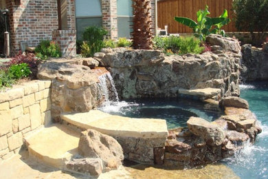 Pool fountain - backyard stone pool fountain idea in Dallas