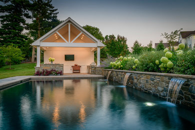 Foto de piscina con fuente actual rectangular en patio trasero con adoquines de piedra natural