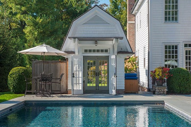 Diseño de casa de la piscina y piscina alargada de estilo de casa de campo de tamaño medio rectangular en patio trasero con suelo de baldosas