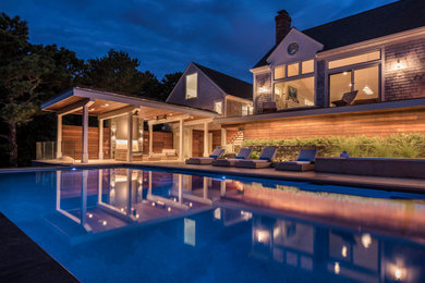 Inspiration for a huge modern backyard rectangular infinity hot tub remodel in Boston