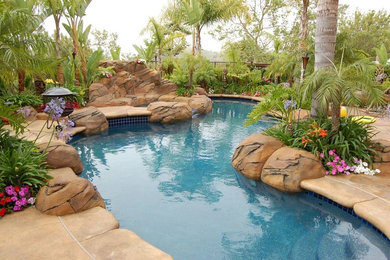 Diseño de piscinas y jacuzzis naturales exóticos de tamaño medio a medida en patio trasero con losas de hormigón