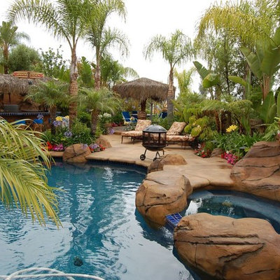 Example of a mid-sized island style backyard concrete and custom-shaped natural hot tub design in Denver