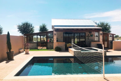 Diseño de casa de la piscina y piscina de estilo de casa de campo rectangular en patio trasero con suelo de hormigón estampado