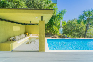 Modelo de piscina alargada actual grande rectangular en patio lateral con entablado