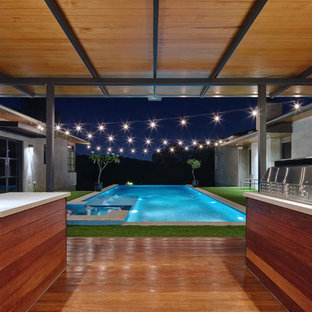 Immagine di una piscina a sfioro infinito minimal rettangolare in cortile con una vasca idromassaggio e pedane