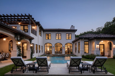 This is an example of a large mediterranean back rectangular swimming pool in Austin with a water feature and tiled flooring.