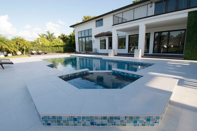 Immagine di una piscina contemporanea personalizzata di medie dimensioni e dietro casa con piastrelle