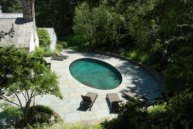 Inspiration for a mid-sized timeless backyard round and stone pool remodel in Boston