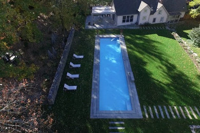 Inspiration for a large contemporary backyard concrete paver and rectangular lap pool remodel in New York