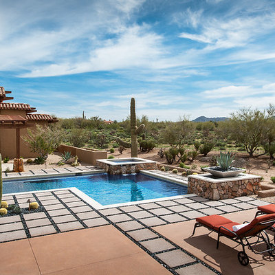 Example of a large southwest backyard concrete paver and l-shaped lap hot tub design in Phoenix