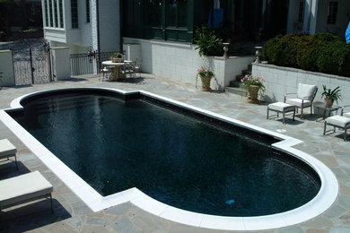 Imagen de piscina alargada actual de tamaño medio a medida en patio trasero con adoquines de piedra natural