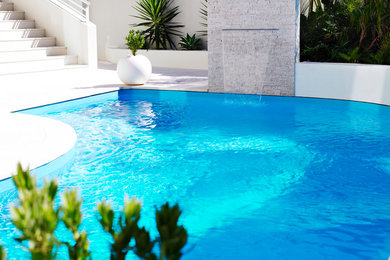 Пример оригинального дизайна: бассейн среднего размера, произвольной формы на заднем дворе с фонтаном