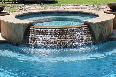 Large mountain style backyard concrete and kidney-shaped natural hot tub photo in Houston