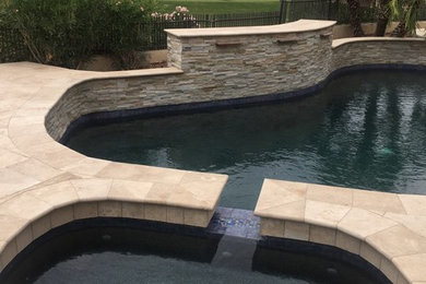 Inspiration for a small contemporary backyard stone and custom-shaped pool fountain remodel in Phoenix