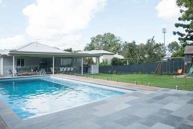 Foto de piscina alargada contemporánea pequeña rectangular en patio trasero con adoquines de hormigón