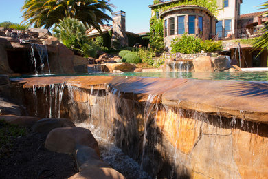 Pool fountain - large mediterranean backyard stone and custom-shaped natural pool fountain idea in San Francisco