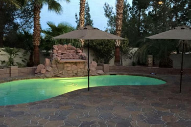 Ispirazione per una piscina monocorsia tradizionale a "C" di medie dimensioni e dietro casa con pavimentazioni in pietra naturale