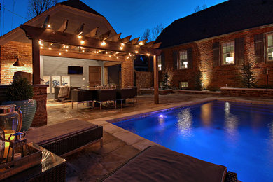 Imagen de piscina con fuente alargada contemporánea de tamaño medio rectangular en patio trasero con adoquines de piedra natural