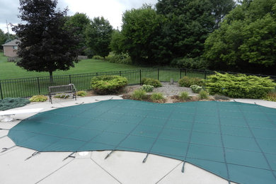 Foto de piscina clásica renovada de tamaño medio a medida en patio trasero con adoquines de hormigón