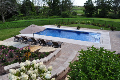 Pool - huge traditional backyard brick and rectangular pool idea in Chicago