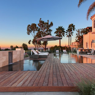 Idee per una piscina a sfioro infinito minimal personalizzata di medie dimensioni e dietro casa con fontane e pedane