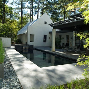 Immagine di una piscina minimalista rettangolare dietro casa con cemento stampato