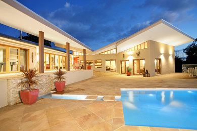 Foto di una piscina naturale minimal a "L" di medie dimensioni e dietro casa con una dépendance a bordo piscina e pavimentazioni in pietra naturale