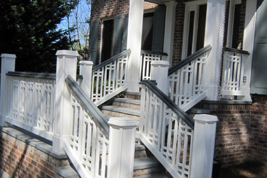 This is an example of a large traditional stone front porch design in Atlanta with a roof extension.