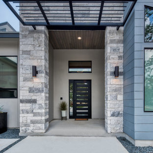Foto di un grande patio o portico minimalista davanti casa con lastre di cemento e una pergola