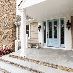 This is an example of a mid-sized traditional front porch design in Boston with a roof extension.