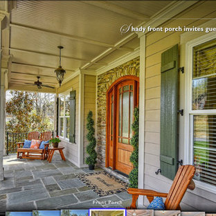 Foto di un grande portico stile americano davanti casa con un tetto a sbalzo e pavimentazioni in pietra naturale