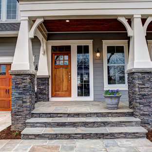 Idee per un portico stile americano di medie dimensioni e davanti casa con un giardino in vaso, pavimentazioni in pietra naturale e un tetto a sbalzo