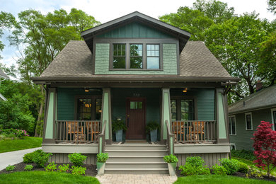 This is an example of a mid-sized craftsman stone front porch design in Detroit with a roof extension.