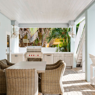 Idee per un portico stile marinaro dietro casa con pavimentazioni in mattoni e un tetto a sbalzo