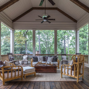Immagine di un ampio portico stile americano dietro casa con un portico chiuso e un tetto a sbalzo