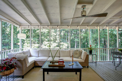 Réalisation d'un très grand porche d'entrée de maison arrière tradition avec une moustiquaire, une terrasse en bois et une extension de toiture.