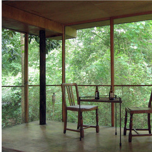 Idee per un piccolo portico etnico dietro casa con un portico chiuso e un tetto a sbalzo