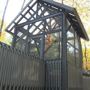 Immagine di un piccolo portico american style dietro casa con un portico chiuso, pedane e un parasole
